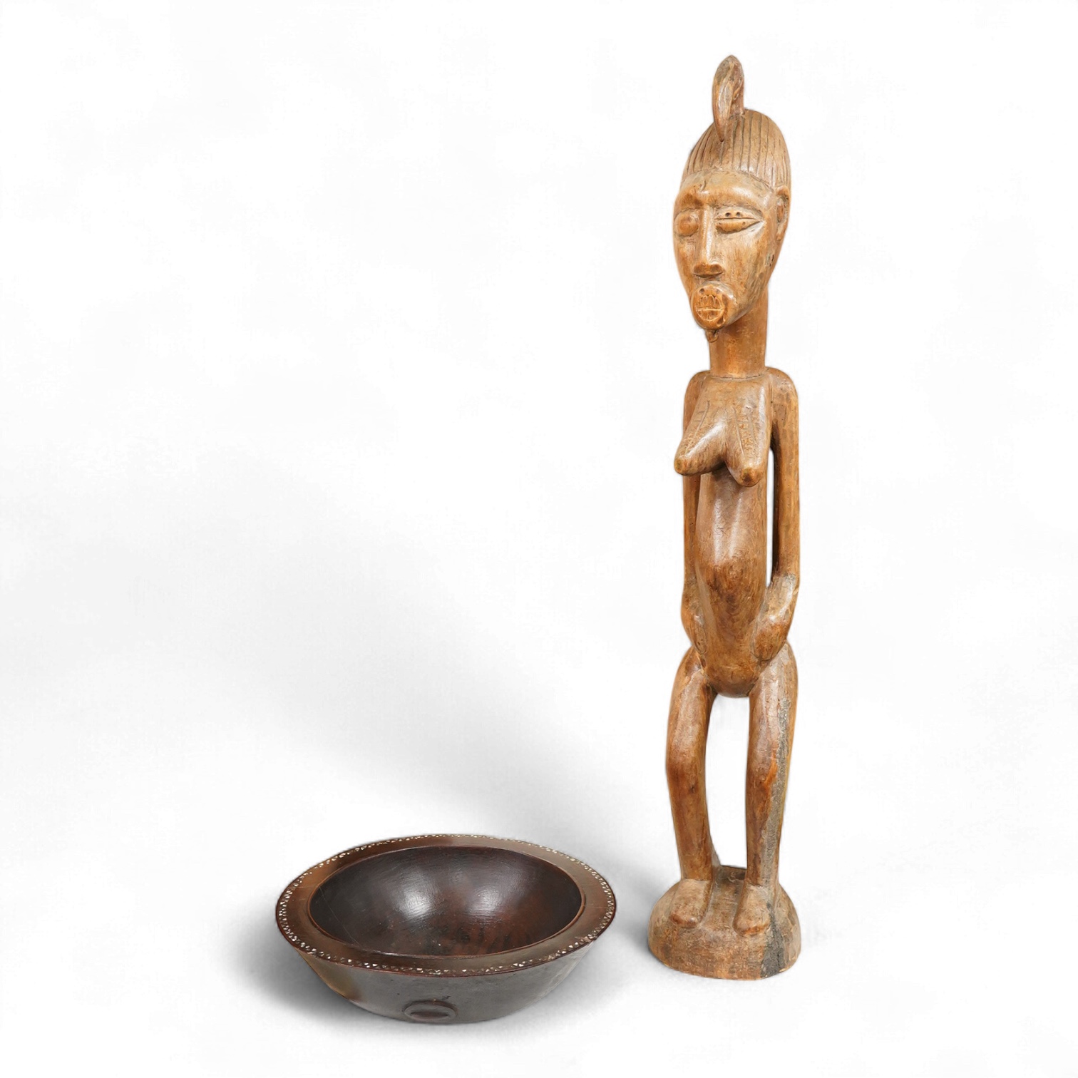 A Fijian carved wood Kava bowl and a West African Dogon fertility figure, 91cm tall